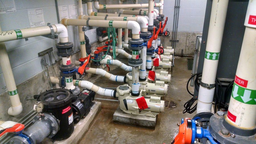 Commercial pool pump room with labelled pipes and valves