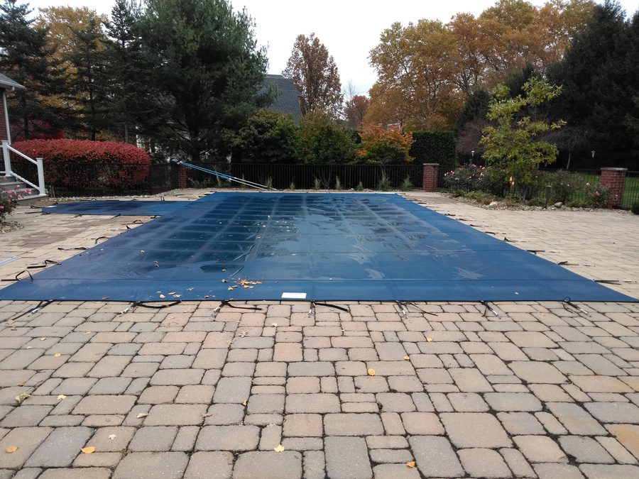 Pool under a mesh safety cover in autumn